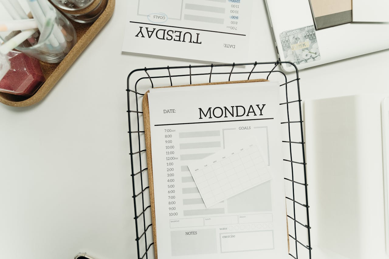 Top view of a modern, minimalist weekly planner setup showing Monday and Tuesday pages.